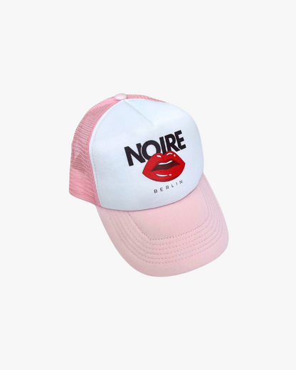 Front view of Noire Berlin/Noire Clothing Candy Pink Trucker Cap featuring red lips logo and white front panel.