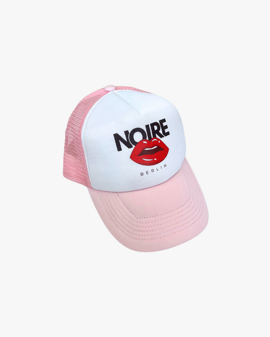 Front view of Noire Berlin/Noire Clothing Candy Pink Trucker Cap featuring red lips logo and white front panel.