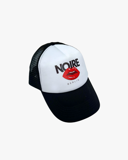 Front view of Noire Berlin/Noire Clothing Classic Black Trucker Cap featuring red lips logo and white front panel.